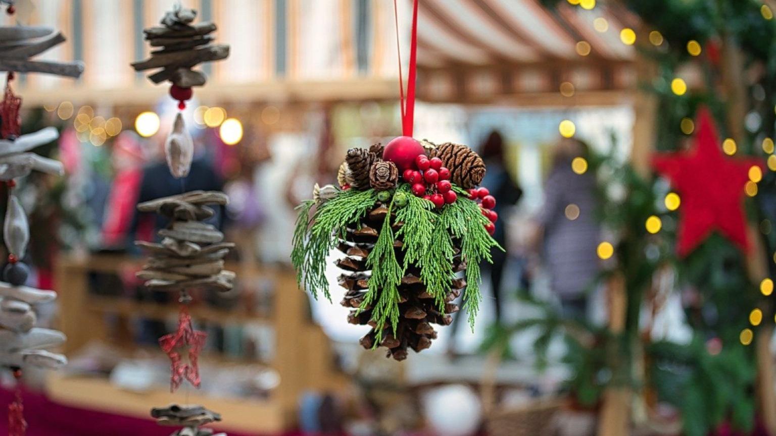 A decorated Christmas tree with a blurry festive market in the background in Porto, Portugal.