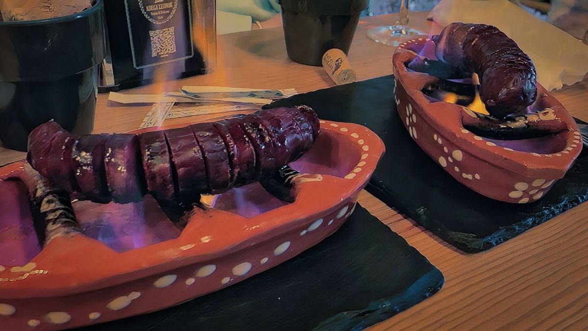 Un chorizo grillé sur le feu, un plat local très apprécié à Porto, à déguster lors de notre visite gastronomique de Porto | Cooltour Oporto