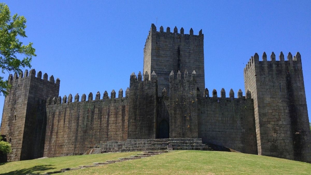 Tour Privado de Braga y Guimarães por Cooltour Oporto: Explore el histórico Castillo de Guimarães con nuestro guía experto.