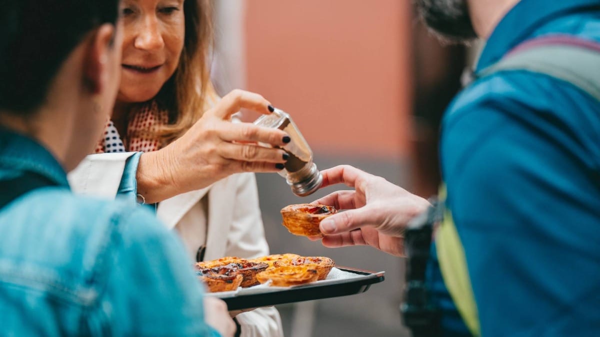 Add cinnamon to your pastel de nata the traditional way during your food tour