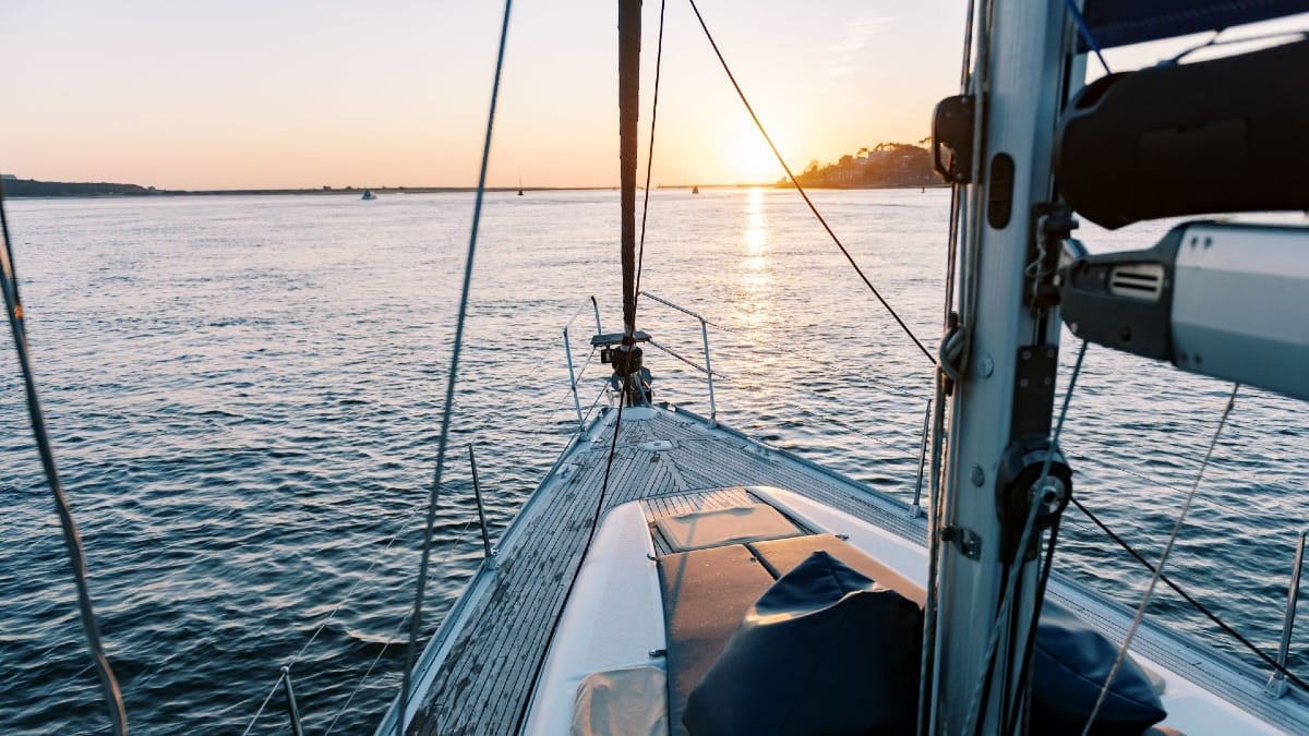 Beautiful sunset view from the boat’s bow with the Foz do Douro skyline and Atlantic Ocean in Porto