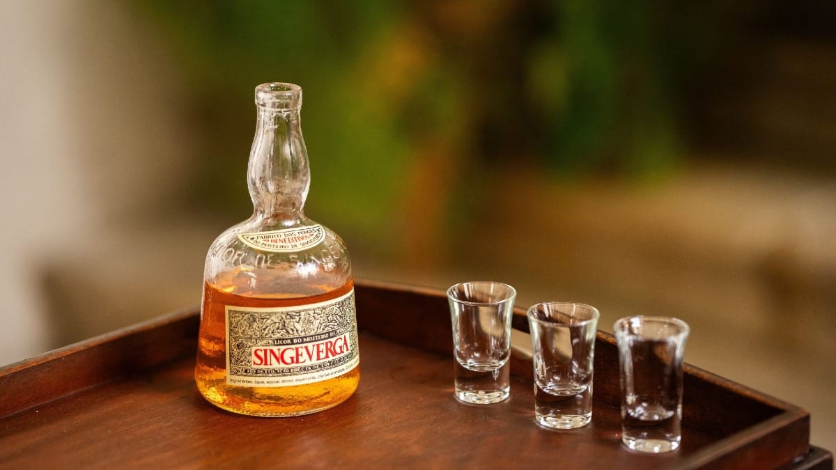 Bouteille de liqueur Singeverga et trois verres sur un plateau, dégustation traditionnelle du monastère à Porto, Portugal