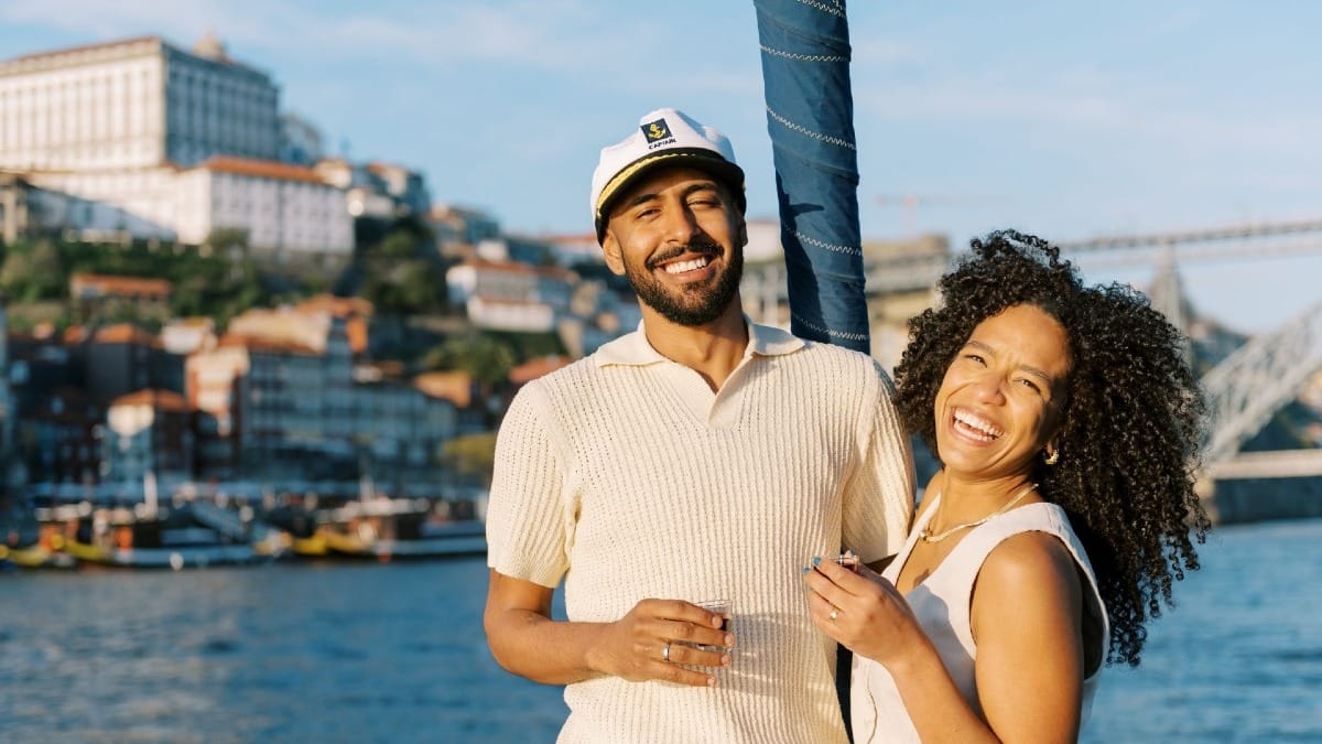 Couple heureux profitant du soleil et de la vue depuis la proue d’un bateau sur le Douro à Porto