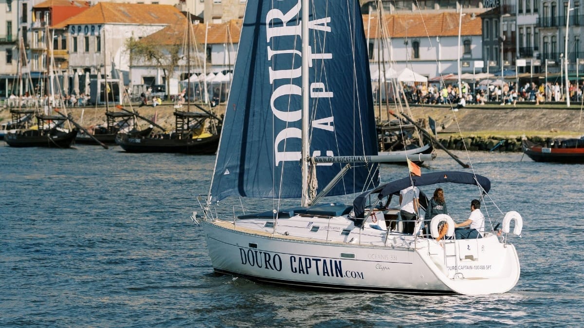Gros plan sur un voilier avec le skipper et des invités profitant du Douro à Porto