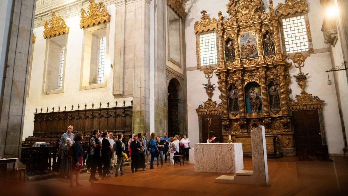 Monk leading a guided tour for visitors inside a historic Monastery in Porto, Portugal, before a Fado performance