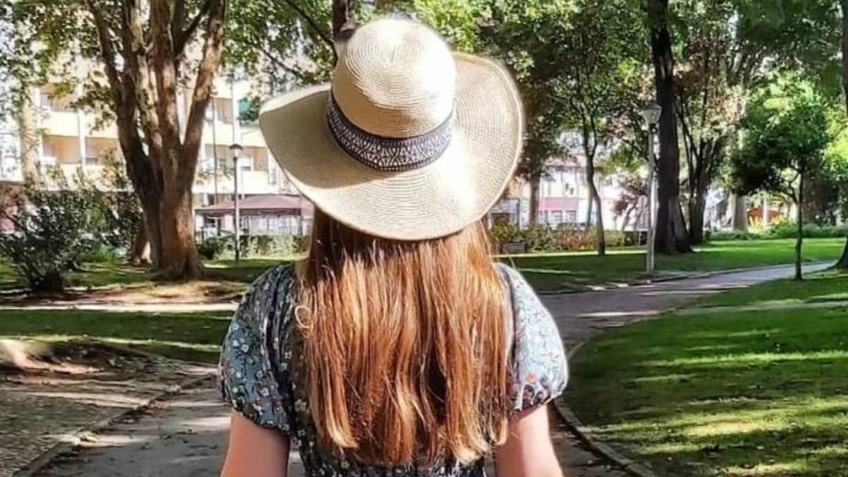 Female guide wearing a summer hat walking through a shaded park in Setúbal during a private tour