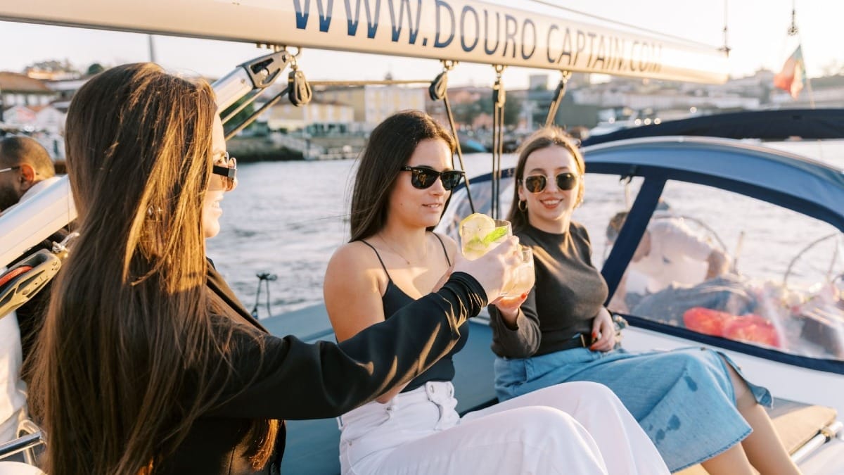 Invités trinquant avec un cocktail lors d'une croisière sur le Douro à Porto