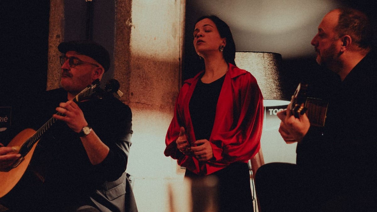 Female Fado singer accompanied by two musicians at an intimate wine bar in Porto