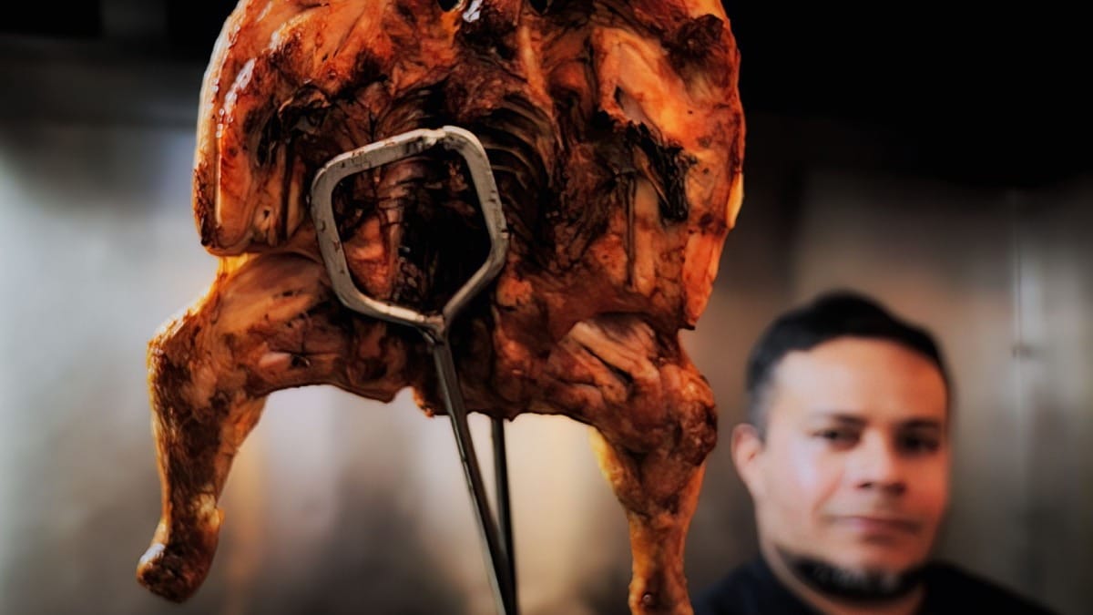 Frango assado inteiro acabado de sair do forno num restaurante de churrasco tradicional no centro do Porto