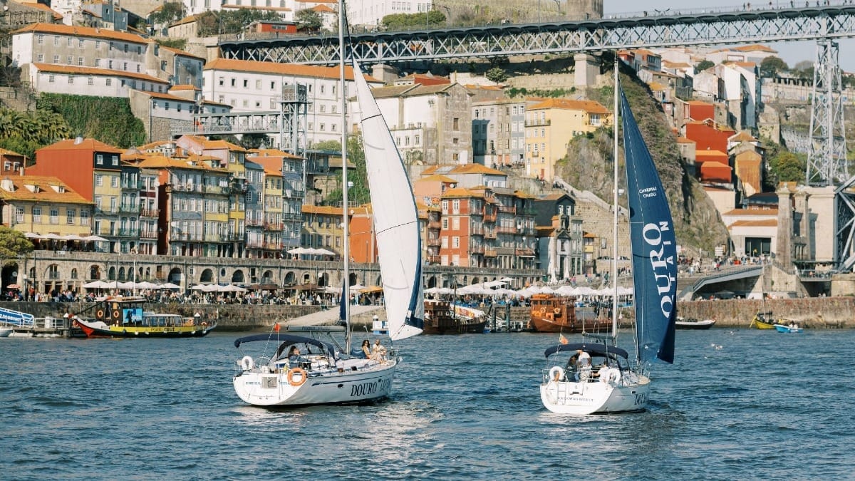 Two sailing boats near Ribeira in Porto, with open sails and spectacular river views