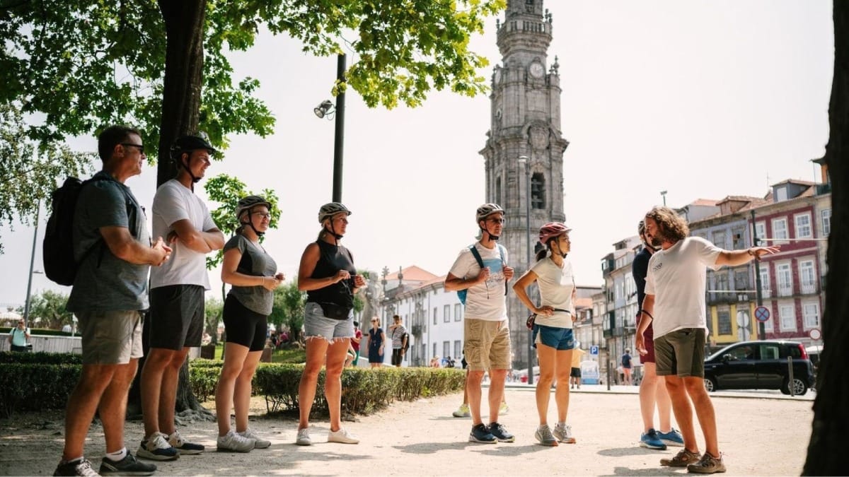 Guide s'arrêtant au Jardin de la Cordoaria, à côté de la Tour des Clercs, pour partager des anecdotes lors d'une visite à vélo électrique de Porto