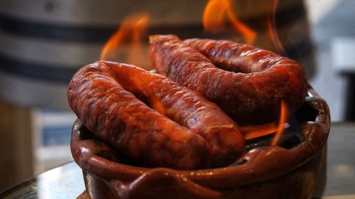 Chorizo portugués servido flambé en un plato de barro en Lagos