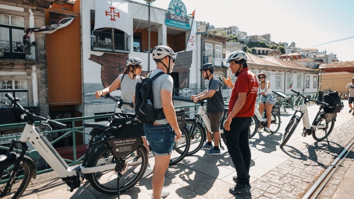 Le guide partage des anecdotes et des faits intéressants avec le petit groupe en vélo électrique devant le Musée des Découvertes de Porto
