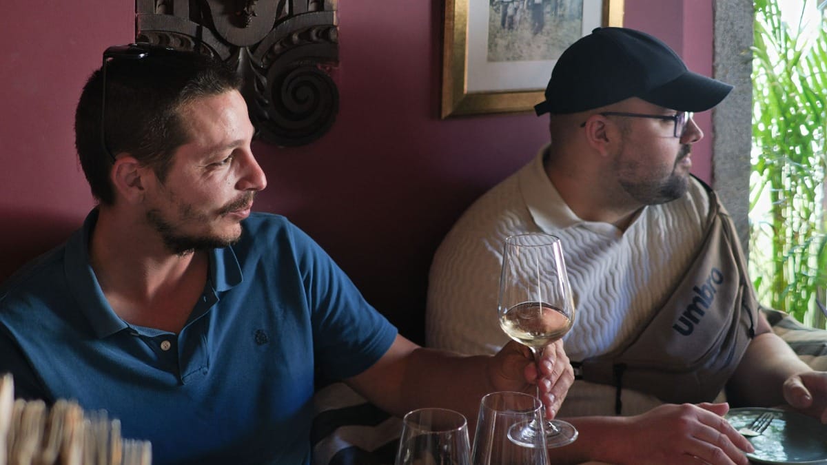 Convidados a relaxar com vinho branco antes de um espetáculo de Fado num bar de vinhos tradicional no Porto por Cooltour Oporto