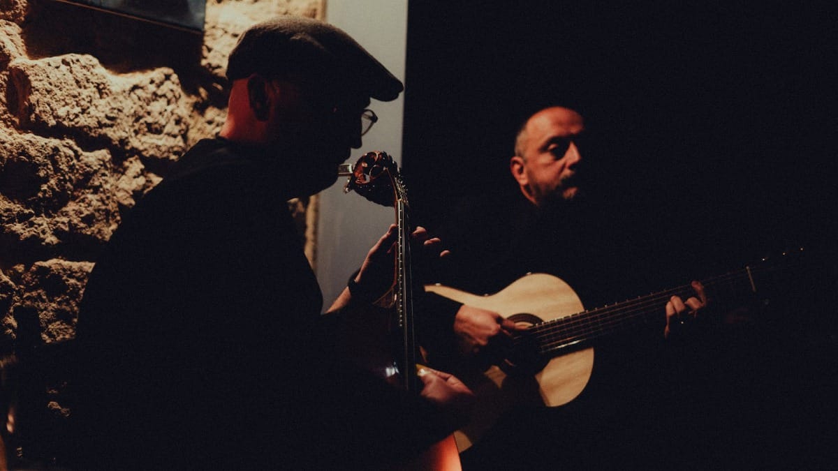 Deux musiciens jouant en direct avec une guitare portugaise et une guitare classique lors d'un dîner-spectacle de Fado à Porto