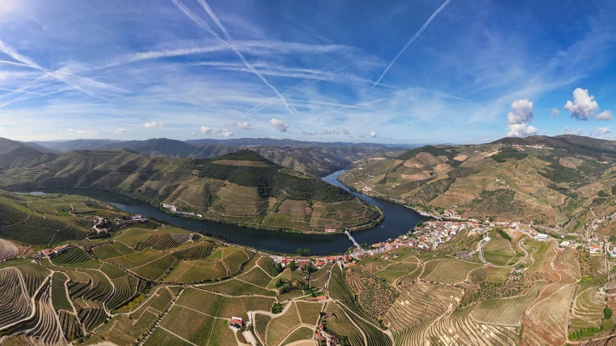 Point de vue à Pinhão sur le fleuve Douro et les vignobles sous un ciel bleu lors d'une visite guidée dans la Vallée du Douro avec Cooltour Oporto