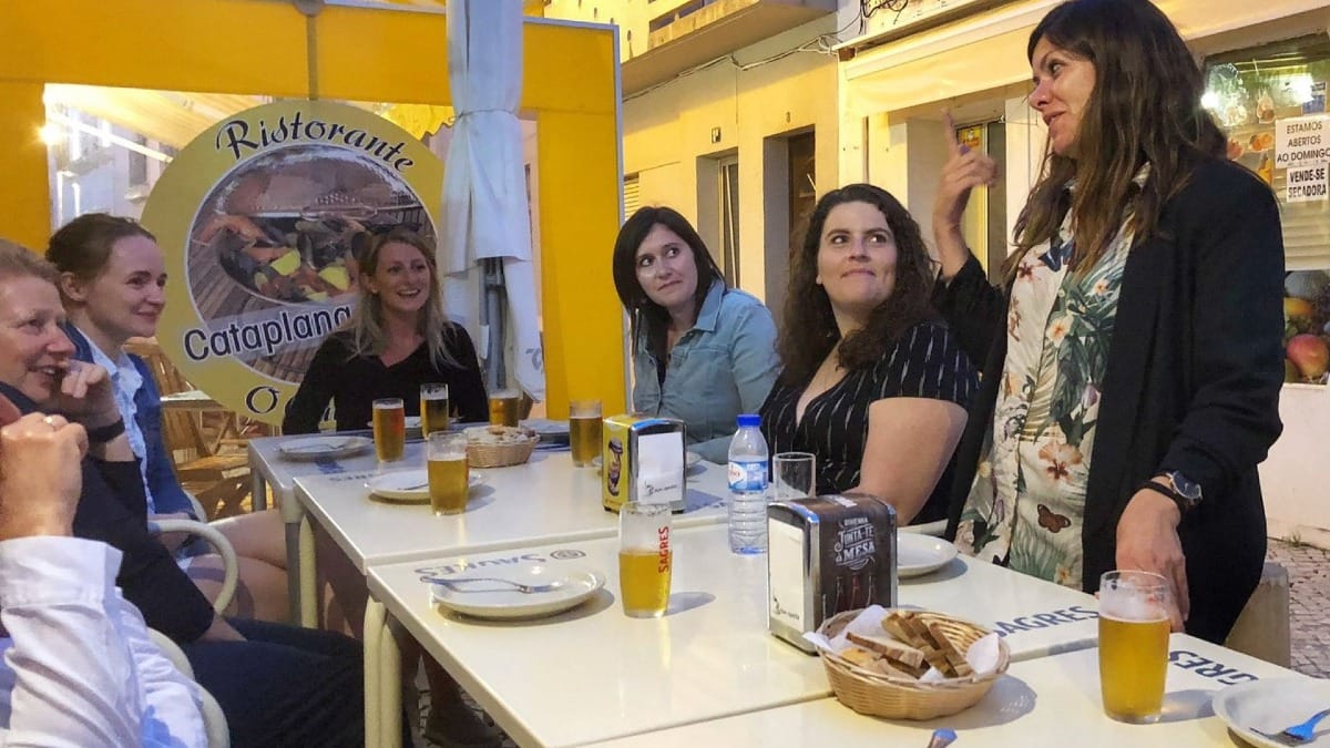 Guia local a dar as boas-vindas aos participantes numa esplanada em Lagos durante o tour