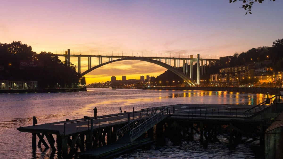 Coucher de soleil spectaculaire derrière le Pont d’Arrábida pendant le Dîner de Fado & Excursion Nocturne à Porto avec Cooltour Oporto