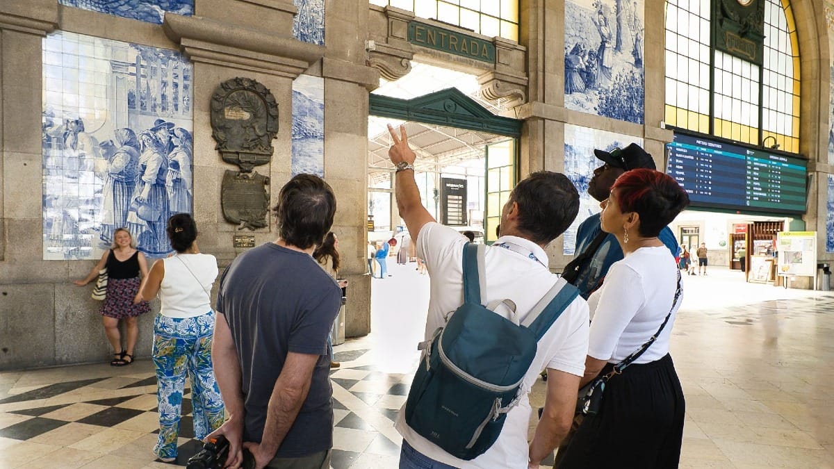 Local guide from Cooltour Oporto explains the tile murals at SĆ£o Bento Station during a cultural food tour in Porto