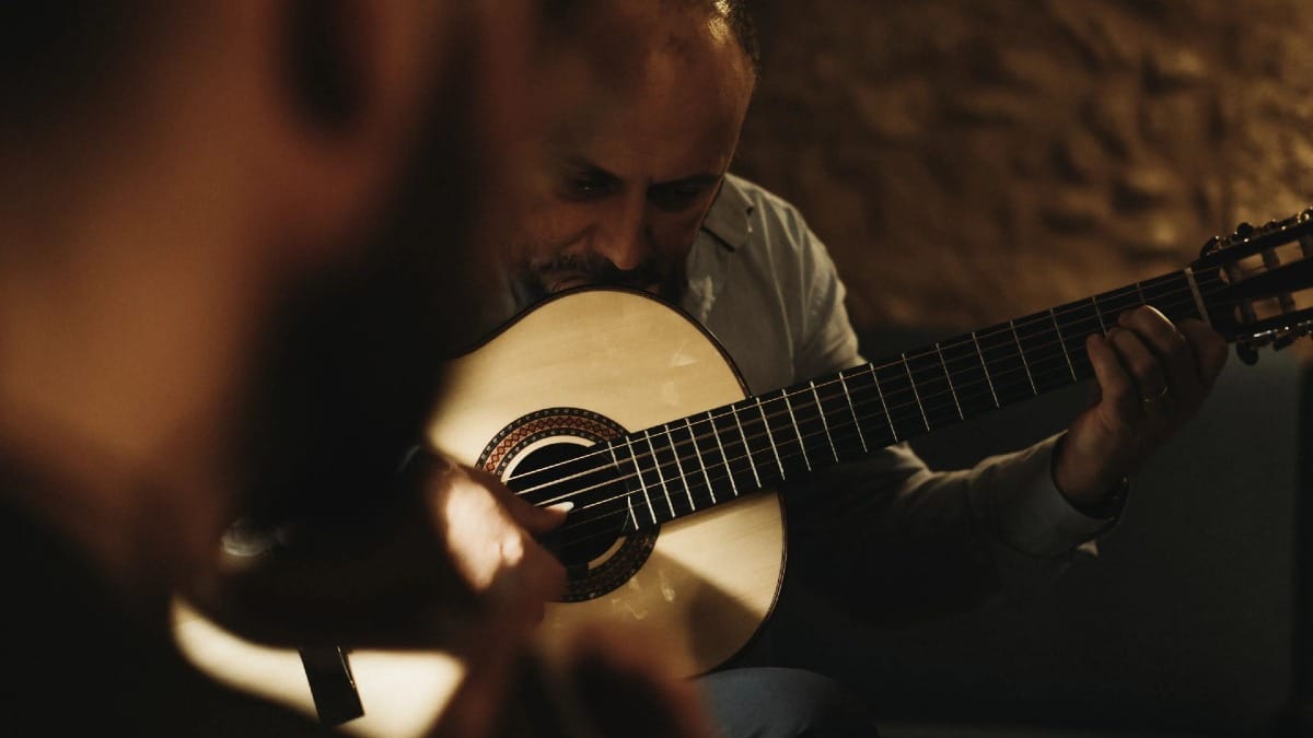 Close-up de guitarrista clássico durante espetáculo de Fado no Porto