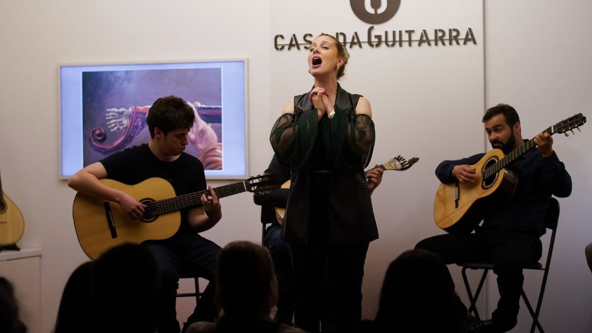 Female Fado singer accompanied by two classical guitarists and a Portuguese guitar player at Casa da Guitarra