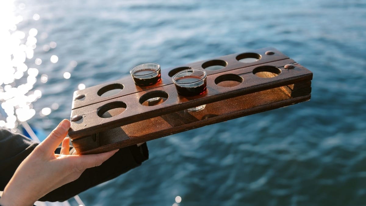 Skipper serving Port wine on a day boat cruise with beautiful river and city views
