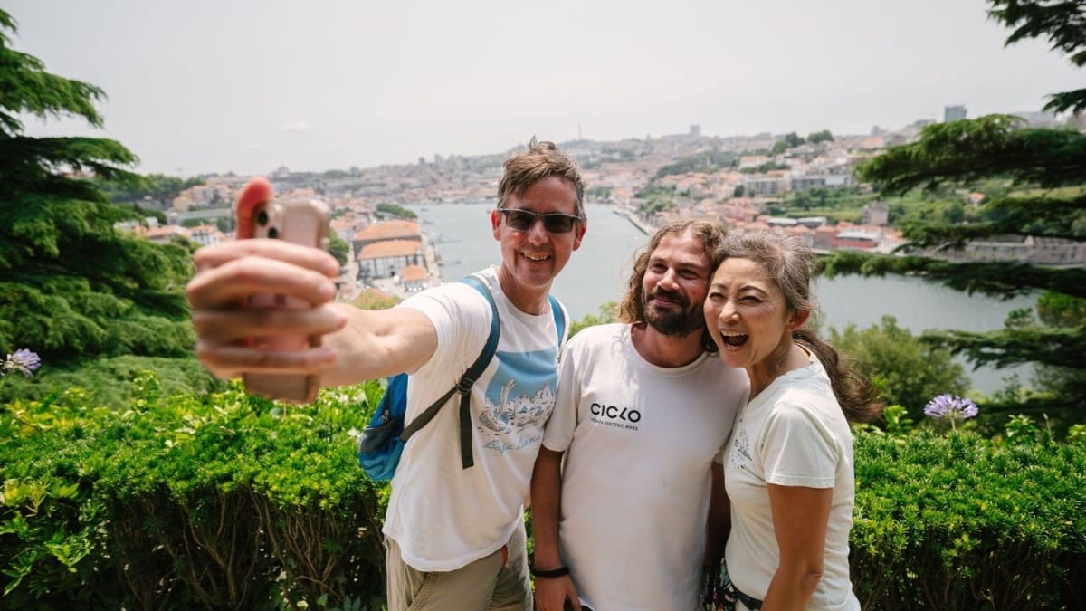 Guests and their guide capturing a photo at Palácio de Cristal viewpoint during an electric bike city tour of Porto