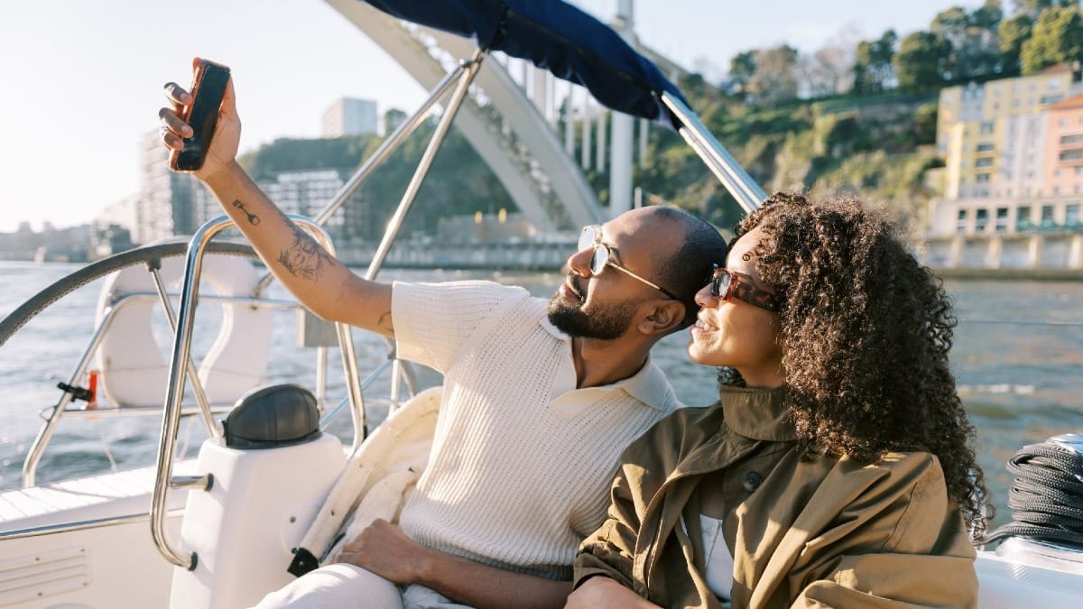Couple taking a selfie during their private boat tour in Porto before the sunset over the Douro