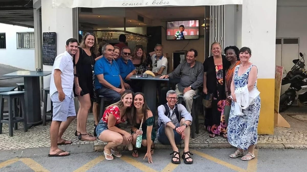 Grupo del tour gastronómico posando para la foto frente a una taberna típica en Lagos