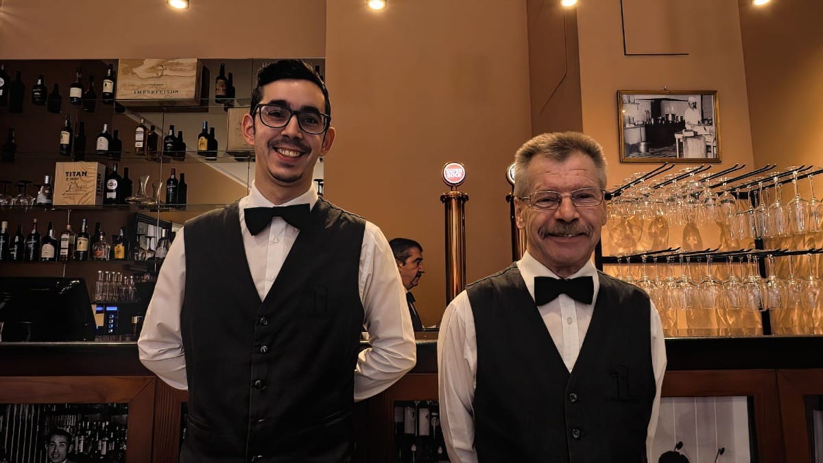 Personal sonriente en el icónico restaurante Regaleira de Oporto, lugar de nacimiento del sándwich Francesinha original