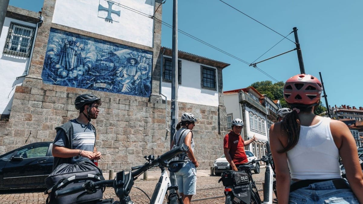 Guide explaining the historic blue azulejos of Infante Dom Henrique during an electric bike tour by Porto’s riverbank