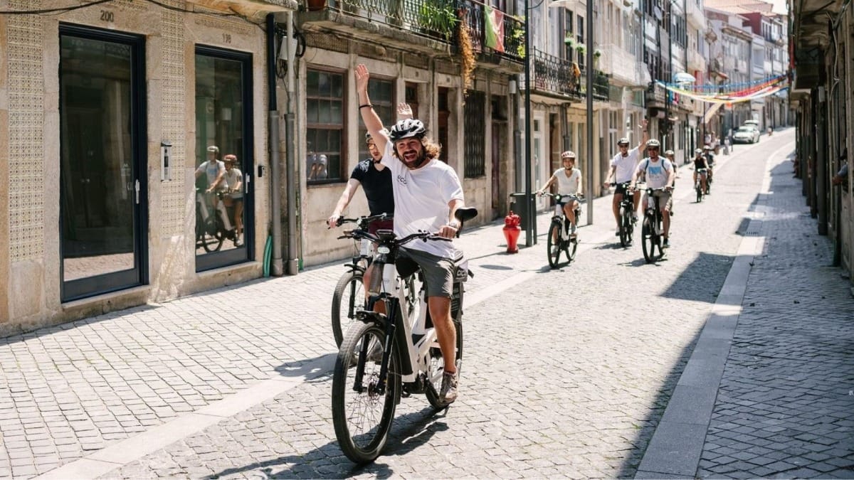 Groupe à vélo électrique à Porto descendant la Rua do Almada, une rue historique du centre-ville près de l’Avenida dos Aliados
