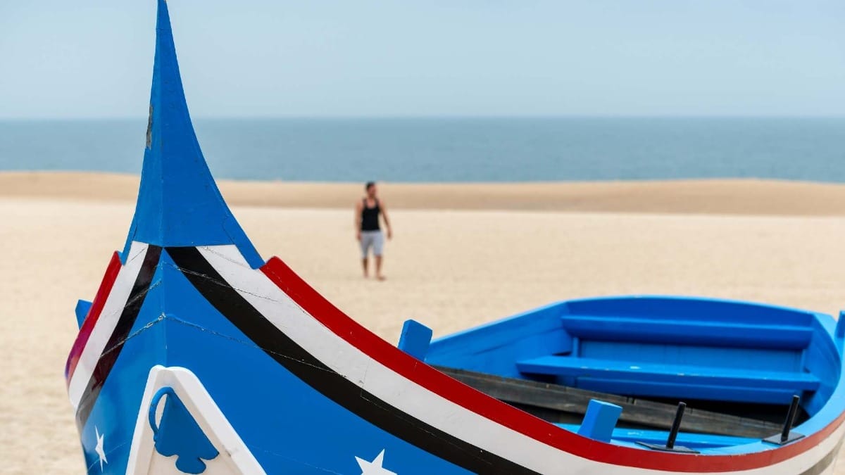WmYl nazare colorful boat on sandy beach