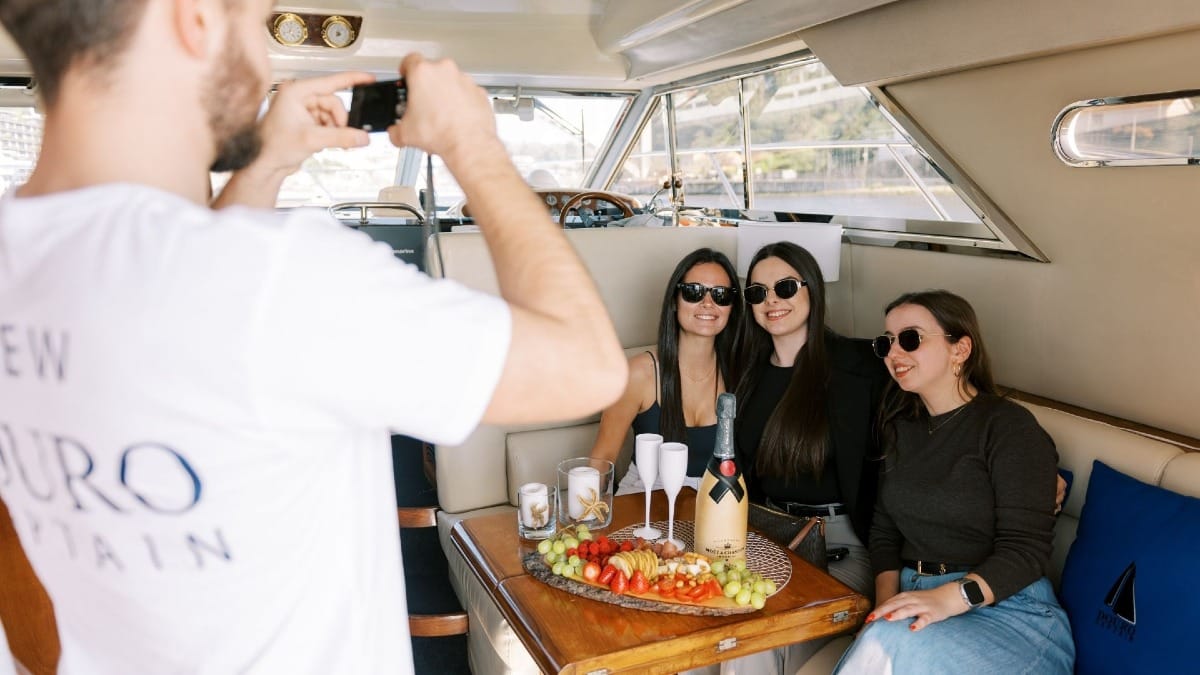 Skipper capturing photos of guests enjoying their private boat cruise on the Douro River in Porto