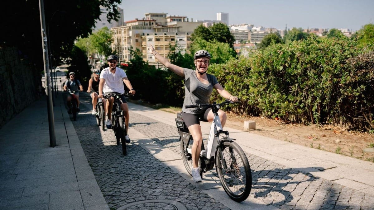 Small group cycling e-bikes up to Serra do Pilar viewpoint for panoramic Porto city and Douro River views
