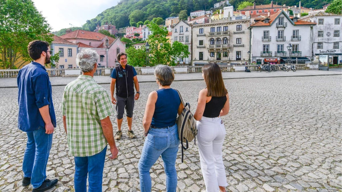Su guía comparte historias y conocimientos locales durante una parada en el pueblo de Sintra.