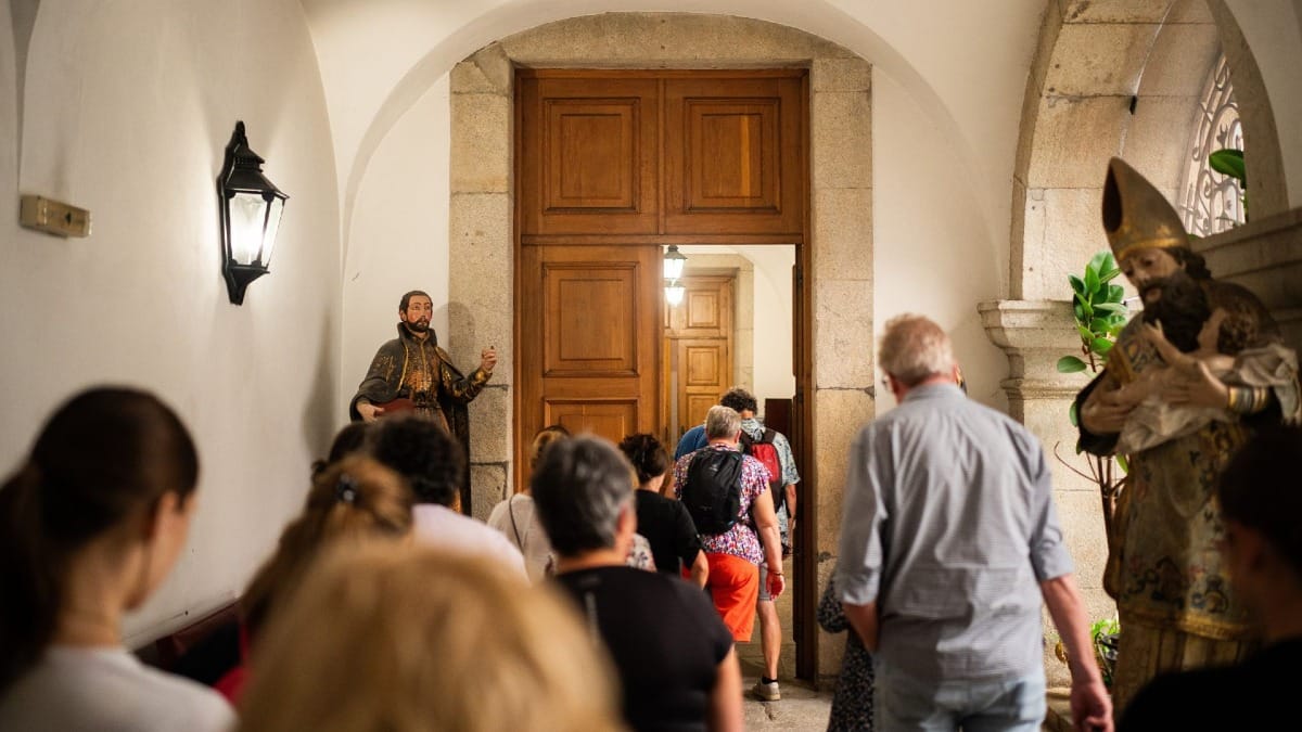 Visiteurs entrant dans une nouvelle salle lors d'une visite guidée du monastère historique à Porto, Portugal