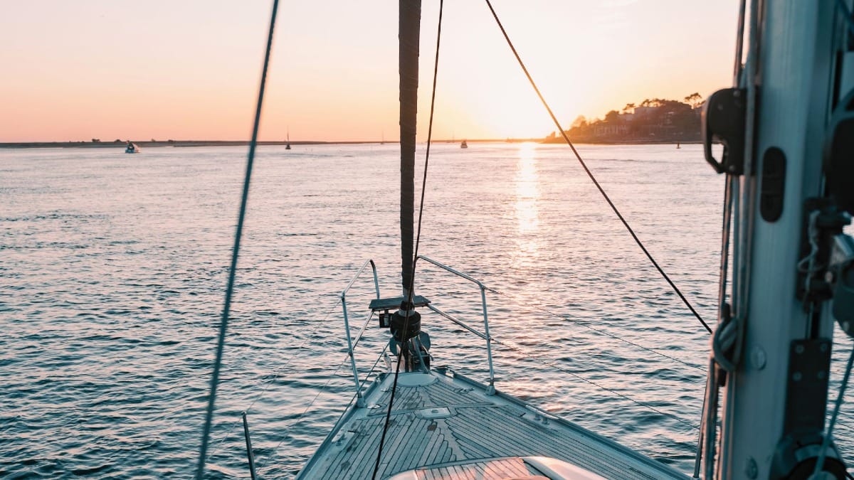 Beautiful sunset light behind Foz do Douro during a sailing boat tour in Porto, Portugal