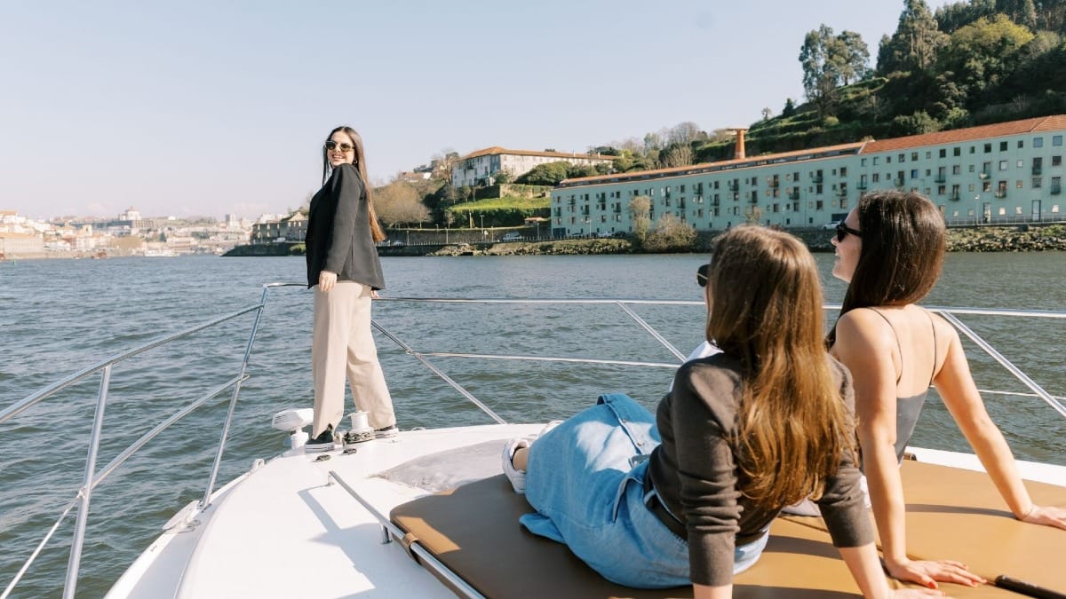 Guests relaxing at the bow of a boat cruise towards Porto