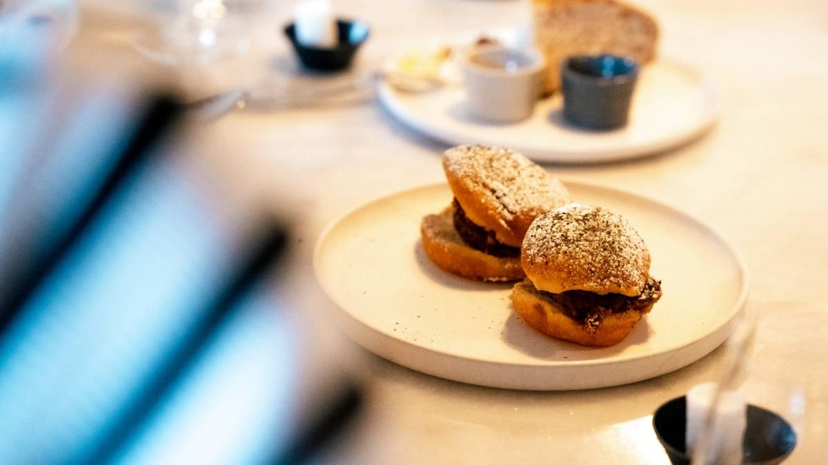 Tender premium meat nestled in soft local bread, part of an exclusive island food and wine experience.