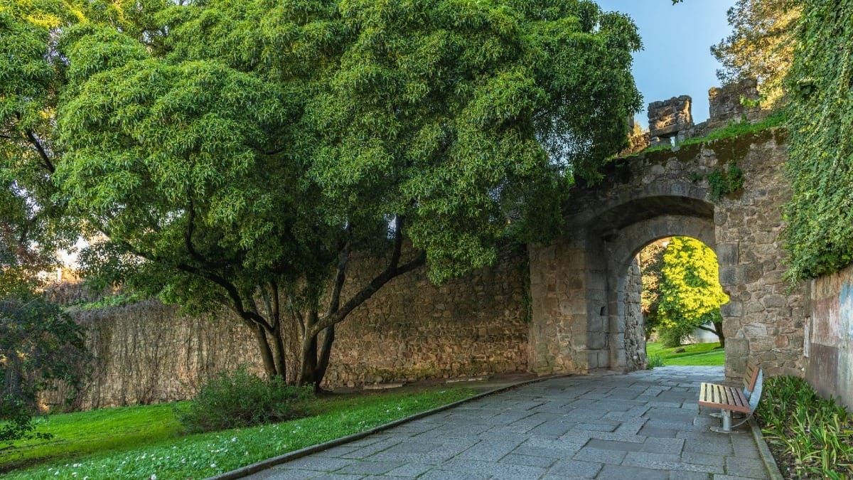 Una de las puertas históricas de las murallas medievales de Évora, que se abre hacia los tranquilos jardines públicos de la ciudad.