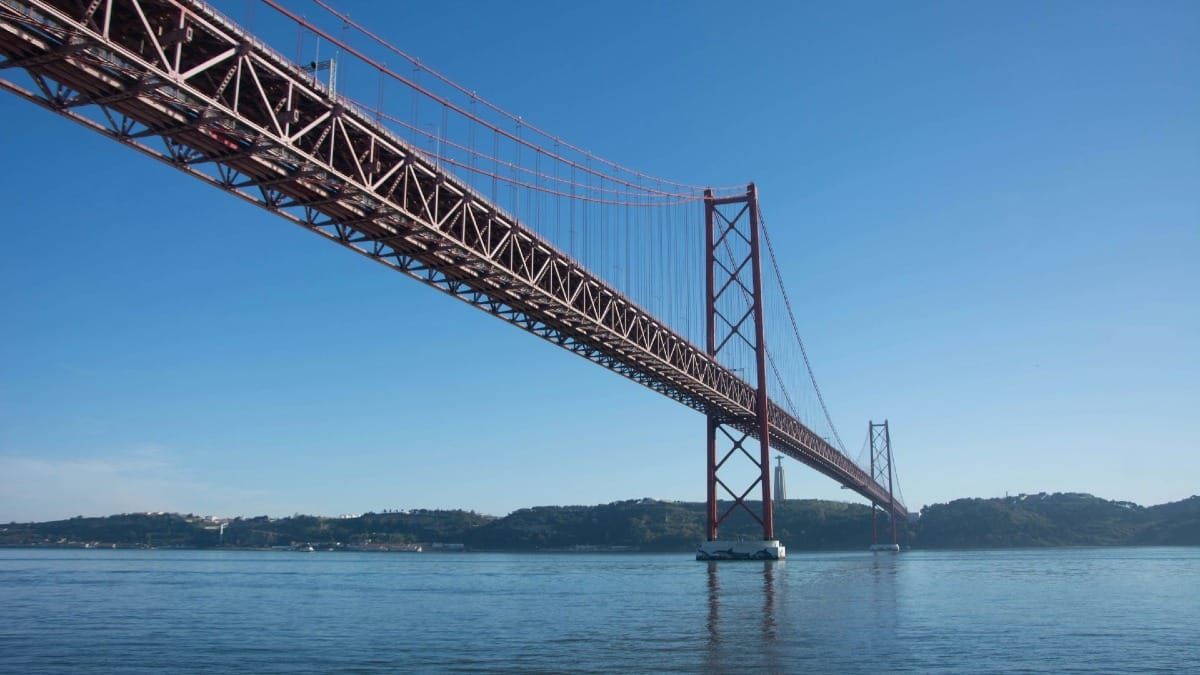 hE1M private boat tour passing lisbon bridge