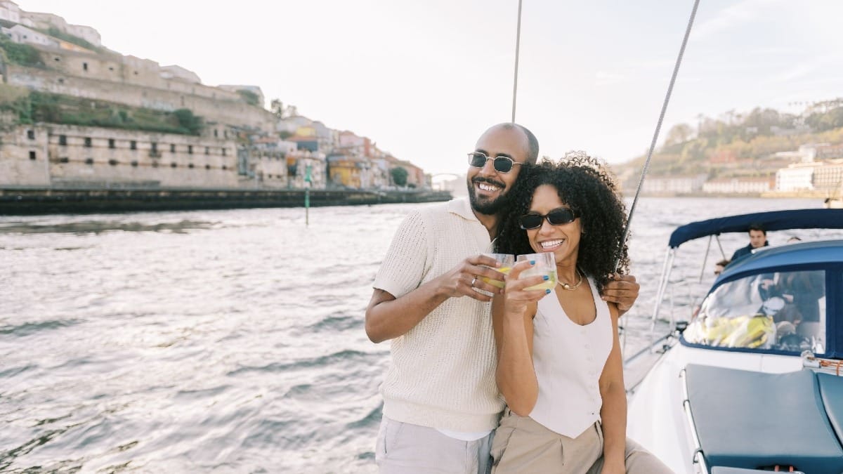 Couple enjoying the scenic sunset view from a boat tour on the Douro river in Porto’s Unesco World Heritage area