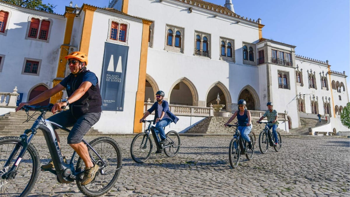 Pasando en bicicleta por el emblemático Palacio Nacional de Sintra, en el centro histórico de la ciudad.
