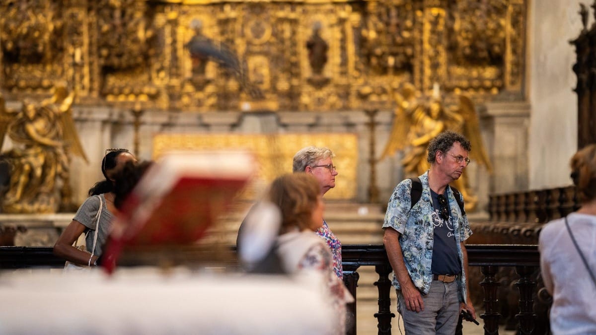 Visiteurs admirant les détails historiques du monastère lors d'une visite guidée à Porto, Portugal