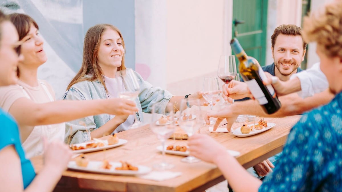 Participantes disfrutando de vinos locales y tapas en una terraza durante el tour gastronómico en Faro