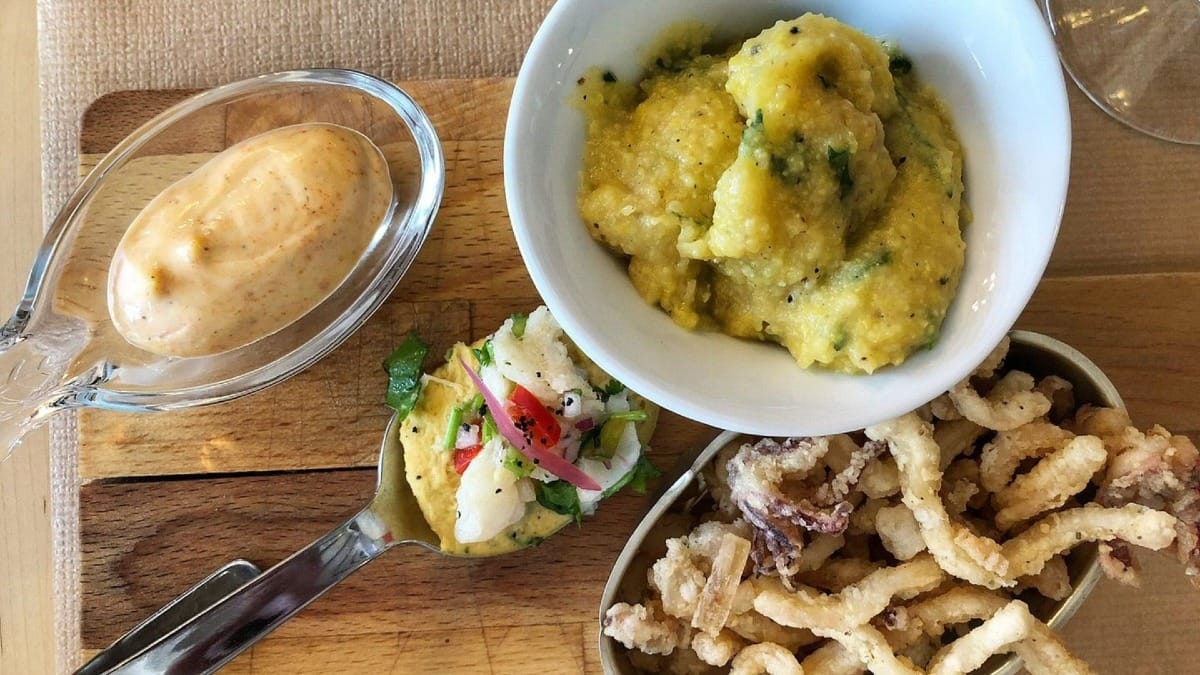 Calamares fritos, ensalada de bacalao, puré de maíz y salsa regional servidos como tapas