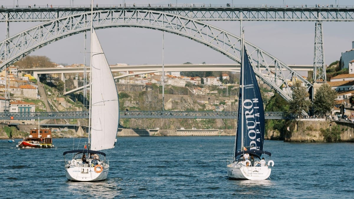 Two sailing boats with open sails on the Douro River, a popular boat tour in Porto by Cooltour Oporto