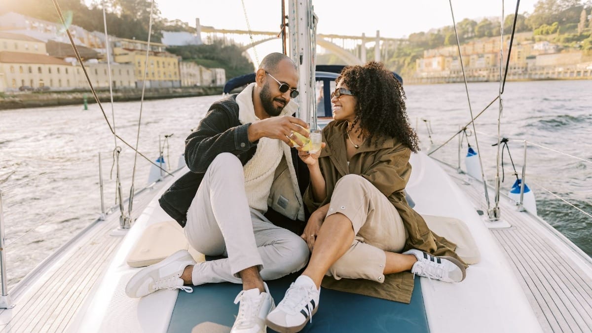 Couple toasting with cocktails on a private sunset sailing boat tour on the Douro River in Porto