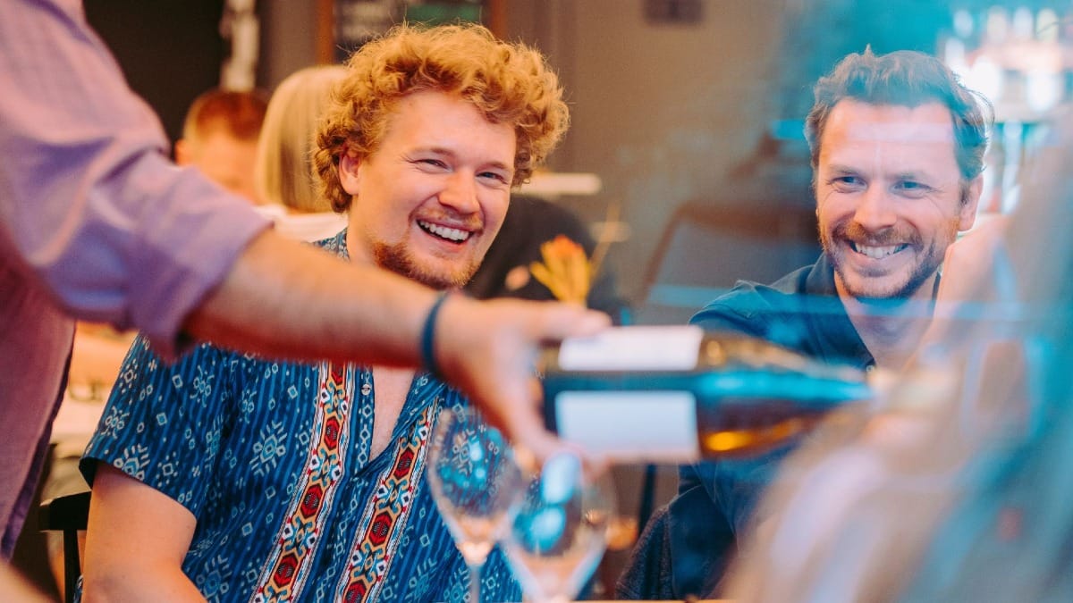Smiling guests enjoying a white wine tasting session during a Faro food tour in the Algarve